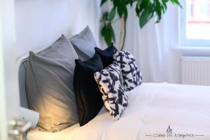 a bed with four pillows on top of it at Casa Wimpina - geschmackvolles Appartement im Herzen der Altstadt in Bad Wimpfen