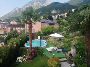 a resort with a swimming pool and a mountain at Relais Garden Lecco in Valmadrera