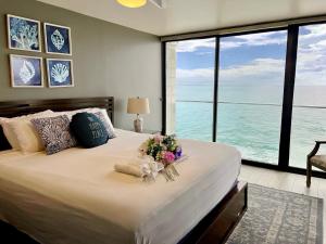 Ocean View Luxury Condo Oceanfront and Pool في سان دييغو: غرفة نوم بها سرير كبير وعليه زهور