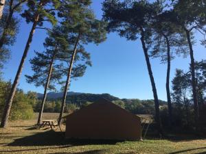 a small shack in the middle of trees at Camping l'Hirondelle Drôme in Menglon