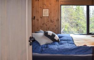 um quarto com uma cama com almofadas e uma janela em 3 Bedroom Awesome Apartment In Rjukan em Rjukan