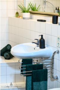 een badkamer met een wastafel en een groene handdoek bij Casa Wimpina - geschmackvolles Appartement im Herzen der Altstadt in Bad Wimpfen