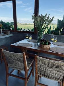 uma mesa com duas cadeiras e copos de vinho em Bruann residence villa 1, Seseh, Perenenan, amazing sunset view and privacy, 2 bedroom em Munggu