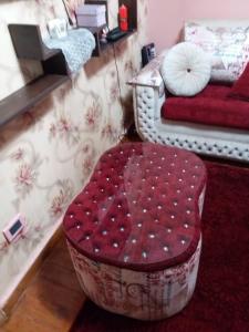 a red ottoman in a living room with a couch at Apartment Close to the sea in Alexandria