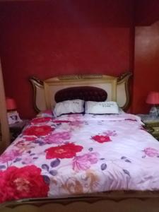 a bed with pink flowers on it in a bedroom at Apartment Close to the sea in Alexandria