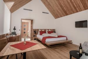a bedroom with a bed and a table with a red rug at Winzerhäuser J&A Skringer in Leutschach