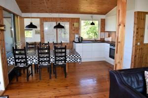 eine Küche und ein Esszimmer mit einem Tisch und Stühlen in der Unterkunft Holiday home with panoramic ocean view near Kerteminde in Martofte