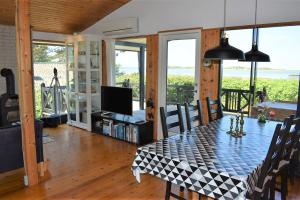 ein Esszimmer mit einem Tisch und einem TV in der Unterkunft Holiday home with panoramic ocean view near Kerteminde in Martofte