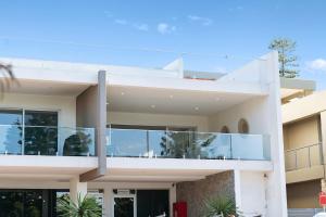 a white house with large glass balconies at Kiama Waterfront Apartment in Kiama