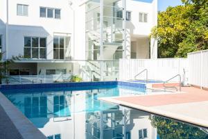 a swimming pool in front of a white building at Kiama Waterfront Apartment in Kiama