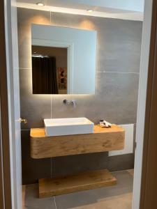 a bathroom with a white sink and a mirror at Majestic Mykonos in Ornos +40 photos