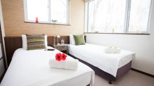 新雪谷的住宿－塔摩度假屋，带两张床和两个窗户的房间
