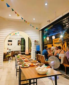 - une longue table avec des plats dans un restaurant dans l'établissement Back Home Backpackers, à Bangkok