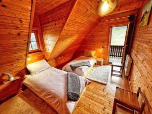 a bedroom with two beds in a wooden cabin at Kuća za odmor Snowdrop in Begovo Razdolje