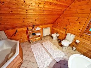 a wooden bathroom with a toilet and a sink at Kuća za odmor Snowdrop in Begovo Razdolje