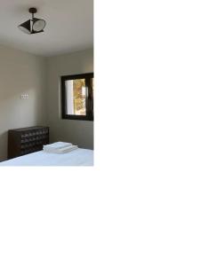 1 dormitorio con 1 cama y ventilador de techo en Casa com jardim perto da praia, en Sesimbra