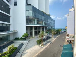 una strada vuota di fronte a un edificio con palme di Home Stay Ruby Nha Trang a Nha Trang