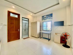 bagno con lavandino, scrivania e porta di Home Stay Ruby Nha Trang a Nha Trang
