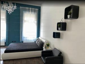 1 dormitorio con 1 cama, TV y silla en Brill Apartment, en Budapest