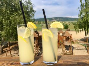 three glasses of lemonade sitting on a wooden table at Hétkúti Wellness Hotel in Mór
