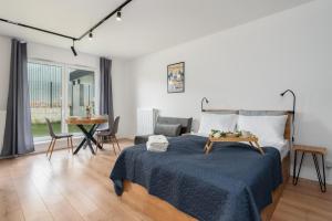 um quarto com uma cama e uma sala de estar em Apartments with Garden Dmowskiego 81 by Renters em Poznań