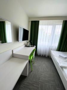 a hotel room with a desk and a window at Jantar Resort in Szczecin