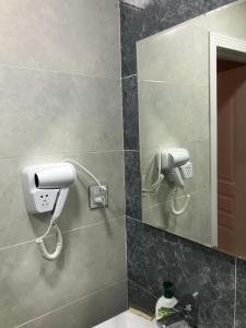 a bathroom with a hair dryer and a phone on the wall at VIP апартамент in Sumqayyt