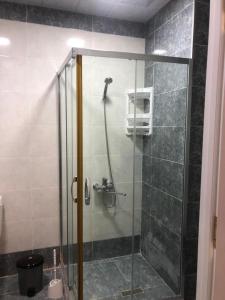 y baño con ducha y puerta de cristal. en VIP апартамент en Sumqayıt