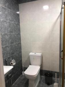 a bathroom with a white toilet and a sink at VIP апартамент in Sumqayyt