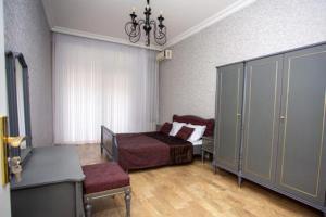 a bedroom with a bed and a chair and a cabinet at VIP апартамент in Sumqayyt
