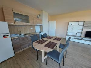a kitchen with a table and chairs and a refrigerator at INTER EXPO APARTMENT in Sofia