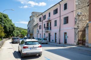 a car parked on the side of a street with buildings at Twins Amphitheatre Apartments in Pula