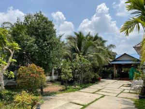 een tuin met palmbomen en een gebouw bij Đông's Garden Home in Can Tho