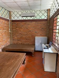 una habitación con 2 bancos y un ordenador portátil sobre una mesa en Đông's Garden Home, en Can Tho