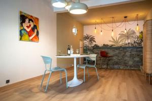een eetkamer met een tafel en stoelen en een schilderij bij Bas de villa- Bastide zebra in Contes