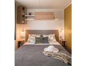 Mobil home 6-8 personnes Camping de la Coulumière 3 étoiles في Villeny: غرفة نوم مع سرير مع قبعة عليه