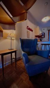 ein Wohnzimmer mit einem blauen Stuhl und einem Tisch in der Unterkunft Este Stay in Este