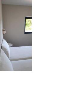 a bedroom with a bed and a window at Casa com jardim perto da praia in Sesimbra