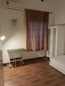 Tenang Retreat Holiday Home في كاجانغ: غرفة نوم مع مكتب وسرير ونافذة