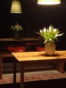 a wooden table with a vase of flowers on it at Settecentoalberi Agriturismo in Noventa di Piave