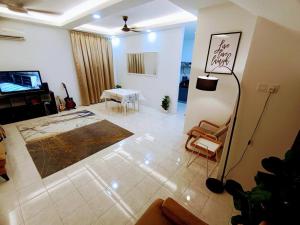 Tenang Retreat Holiday Home في كاجانغ: غرفة معيشة مع تلفزيون وطاولة وكراسي