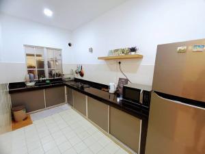 a kitchen with a refrigerator and a counter top at Tenang Retreat Holiday Home in Kajang