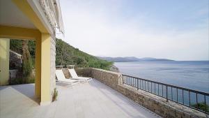 balcone con sedie e vista sull'acqua di Lustica Bay Apartment Honey By 2bhome a Radovići