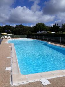 una grande piscina blu con acqua blu di Marennes mobilhome 46 Domaine des pins a Marennes