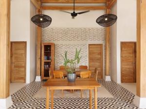 Dalung的住宿－Spaces Bali，一间带木桌和椅子的用餐室