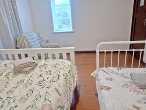 a bedroom with a crib and a chair in it at Little Gem - City Centre in Hamilton