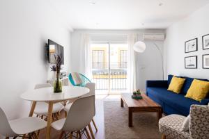 een woonkamer met een blauwe bank en een tafel bij Azahar in Sevilla
