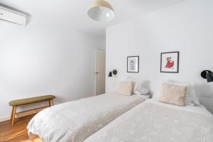1 dormitorio blanco con 2 camas y mesa en Azahar en Sevilla