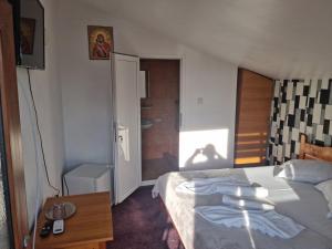 a bedroom with a bed and a table with a television at Vila Ioana & Mirel in Eforie Sud