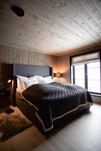 sypialnia z dużym łóżkiem i drewnianym sufitem w obiekcie Strandafjellet Panorama Lodge - Large Cabin with Majestic Mountain View w mieście Stranda